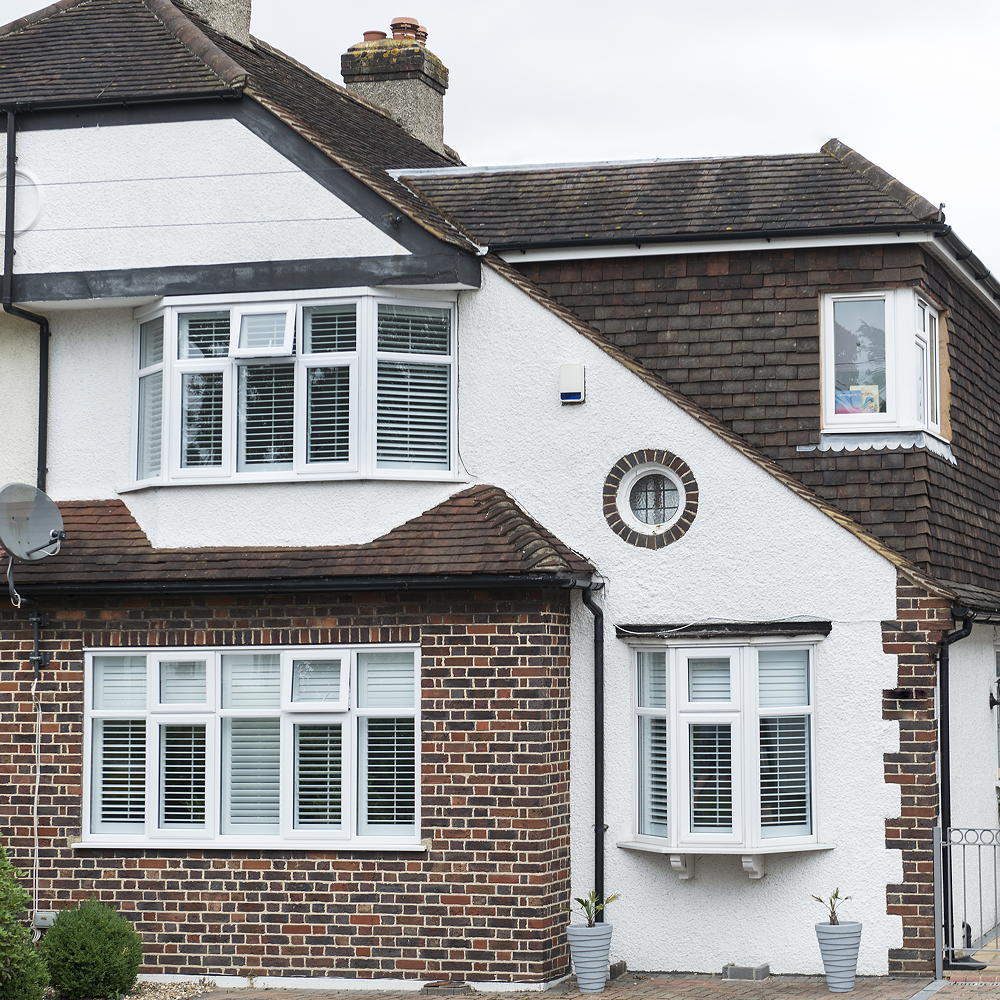 two story red brick and white wall house with white window and red roofing