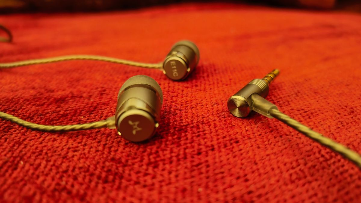 SoundMagic E11C wired headphones on a red backdrop