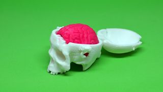 A 3D print of the 'Boneheads: Skull Box w/ Brain,' available on Thingiverse, and printed on the MOD-t. The brain prints in two separate pieces, while the skull prints in one. The skull includes a working hinge and snaps to keep everything in place.