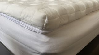 The corner of the Levitex mattress topper on a bed