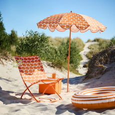 IKEA STRAND&Ouml;N parasol and chair in orange on a beach.