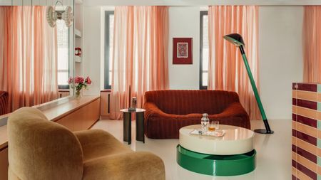 Sheer salmon-colored curtains soften the light across a living room interior full of glossy surfaces