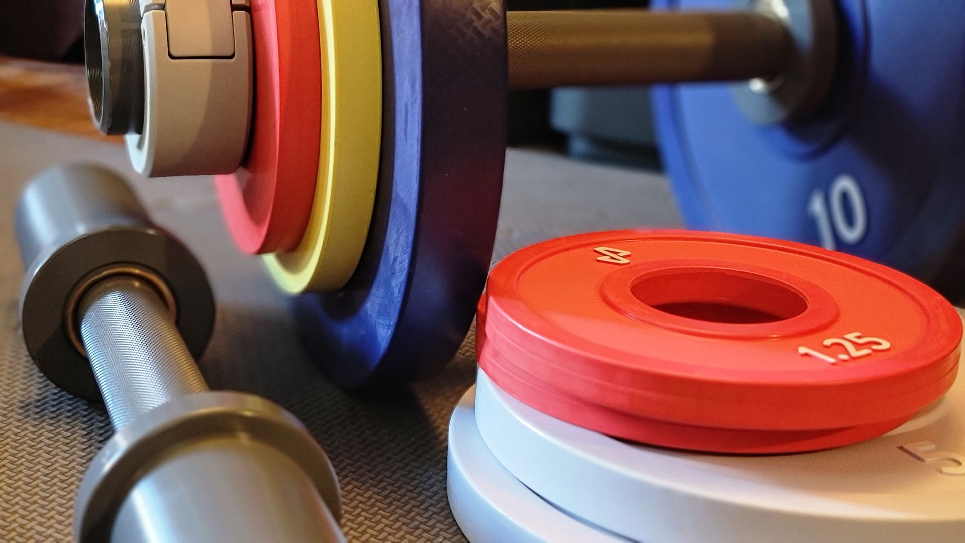 The Tempo Move with several dumbbells and weight plates