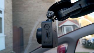 A dash cam mounted on the inside of a windscreen