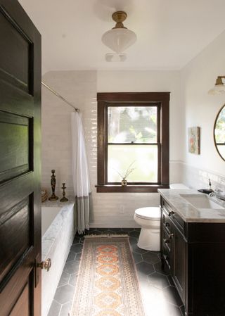 Small rustic bathroom with marble bath and persian rug