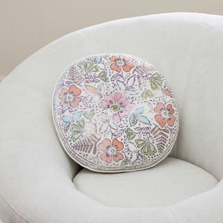 Round Floral Pillow on a chair.