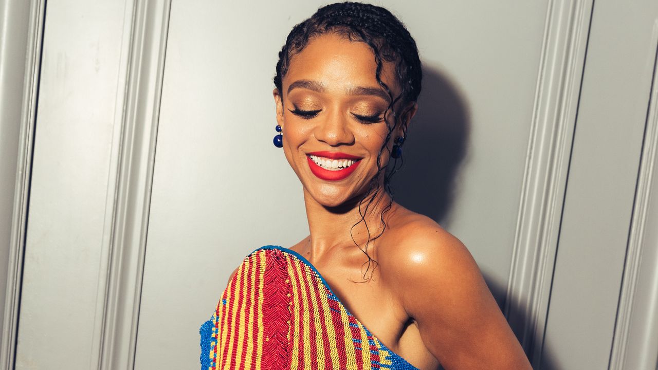 Tiffany Boone stands in front of her hotel suite door wearing a beaded Balmain dress