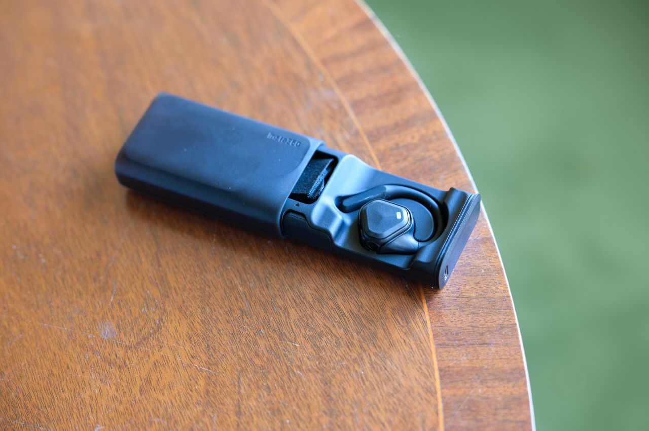 Insta360 POV Head Tracker accessory in its hard shell battery case on a mahogany table