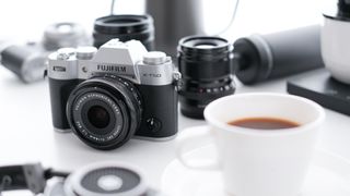Fujifilm X-T50 and lenses on a desk with cup of coffee
