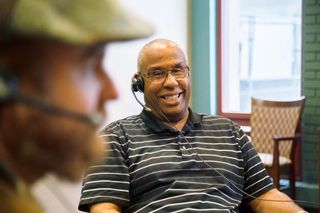 Residents at an assisted living center use ListenTALK technology for hearing assistance.