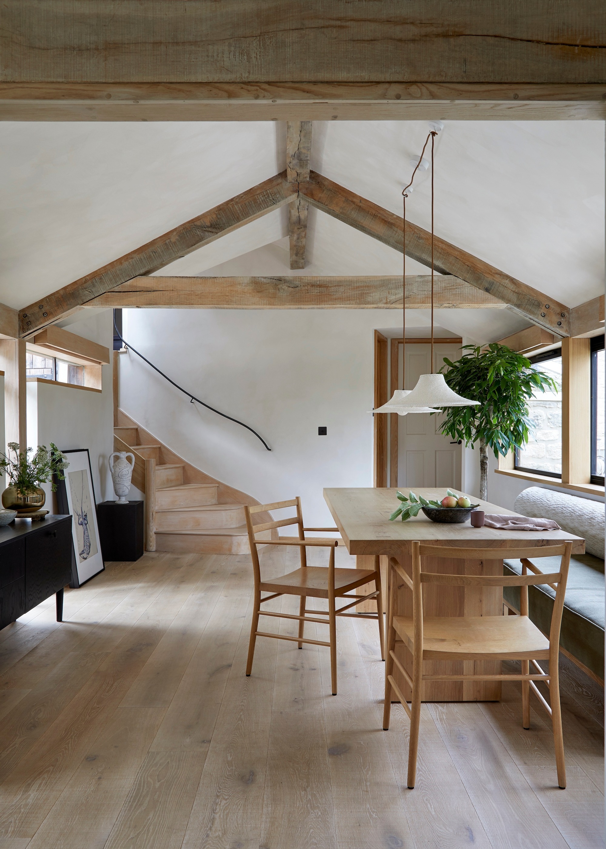 banquette seating with deep cushioned seat pads and timber dining table in vaulted room