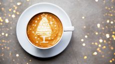 An image of a coffee with Christmas tree latte art served in white ceramic cup