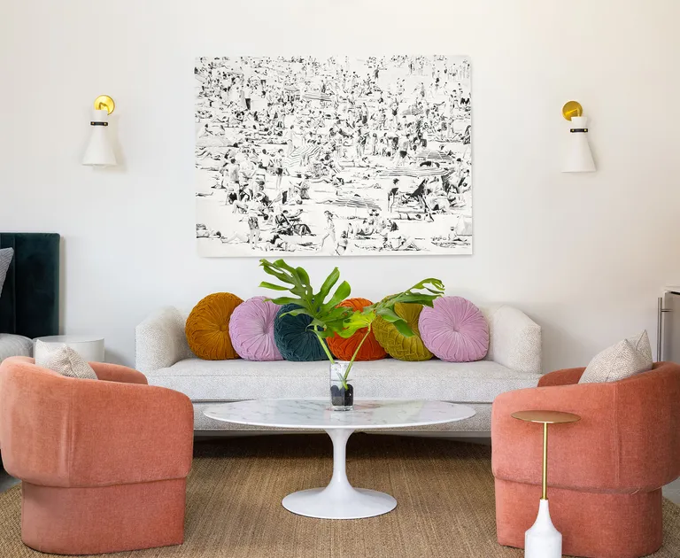 Display of round throw pillows on white couch behind wooden coffee table with plant on display