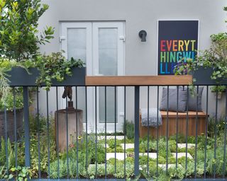 balcony garden with ground cover plants and a wooden garden bench