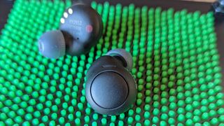 The Sony WF-C500 wireless earbuds on display over a green-dotted backdrop