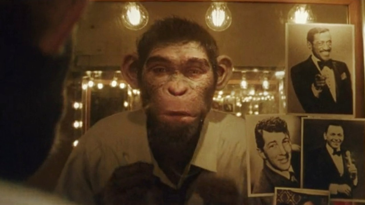 Chimp Robbie Williams looking in mirror in Better Man.