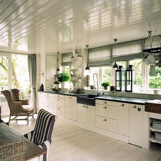 kitchen with white painted panelling and arm chair