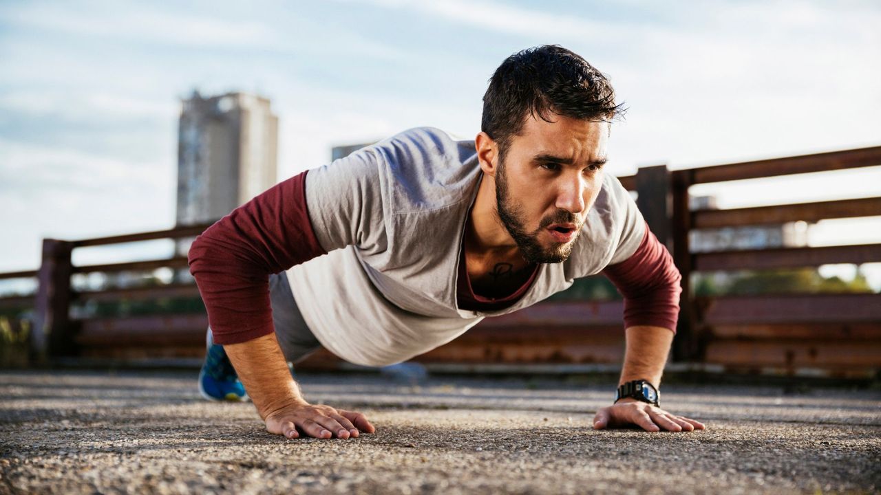 A man performing a push-up as part of a no equipment home workout