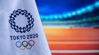 Tokyo 2020 OL flag med atletikstadion i baggrunden