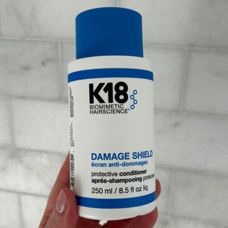 Laura holding K18 Damage Shield Protective Conditioner - best hair conditioner