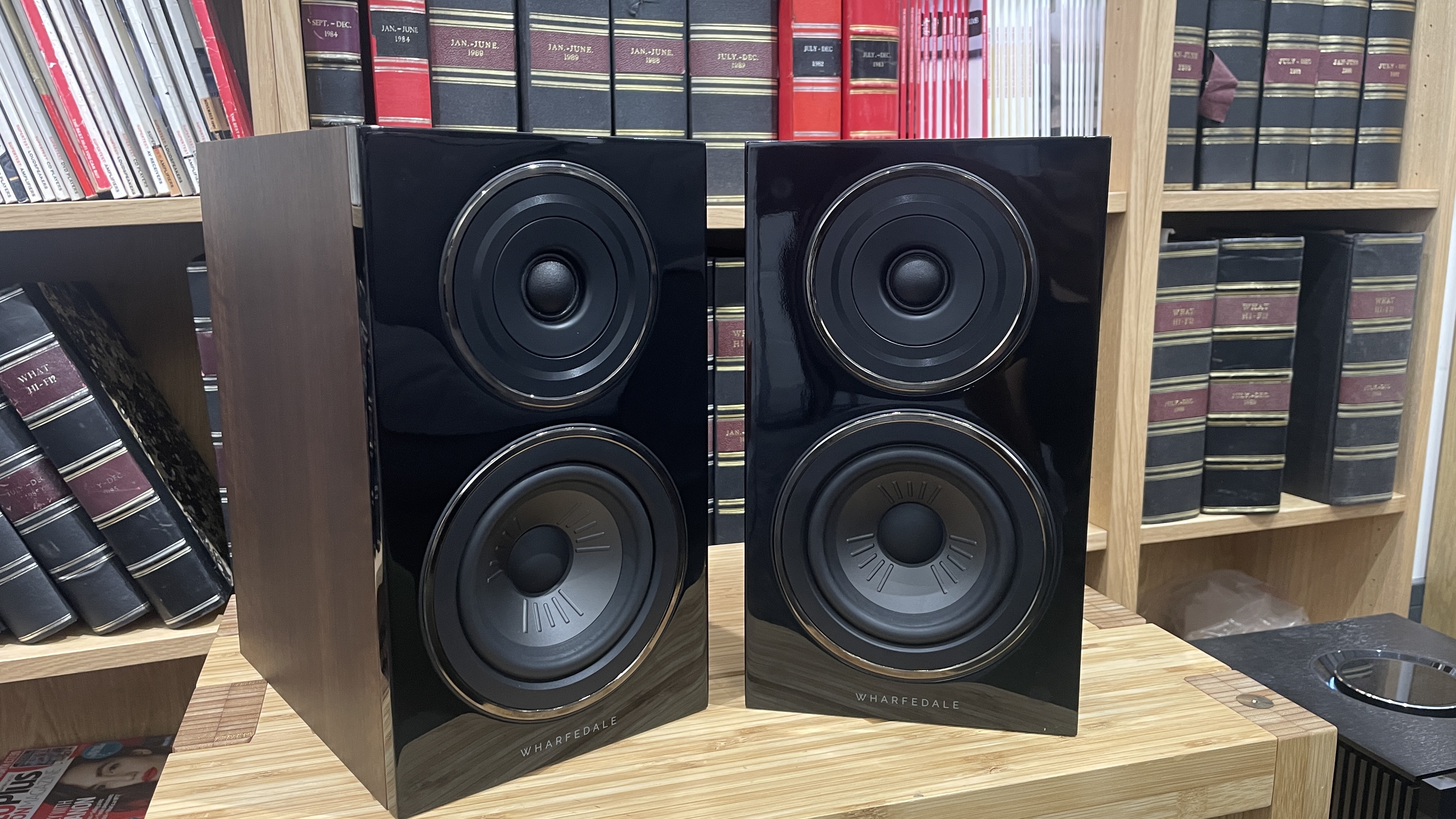 Wharfedale Diamond 12.1 stereo speakers in walnut finish on a wooden rack