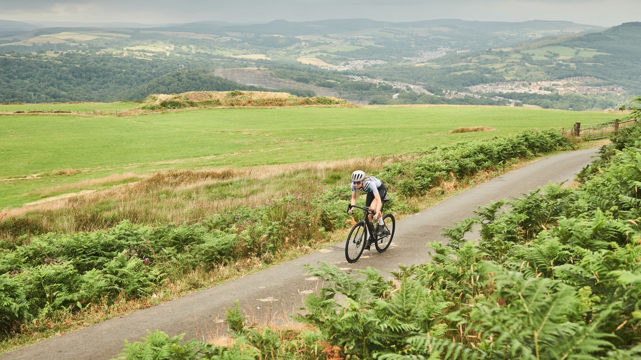 Image shows a rider cycling outside.