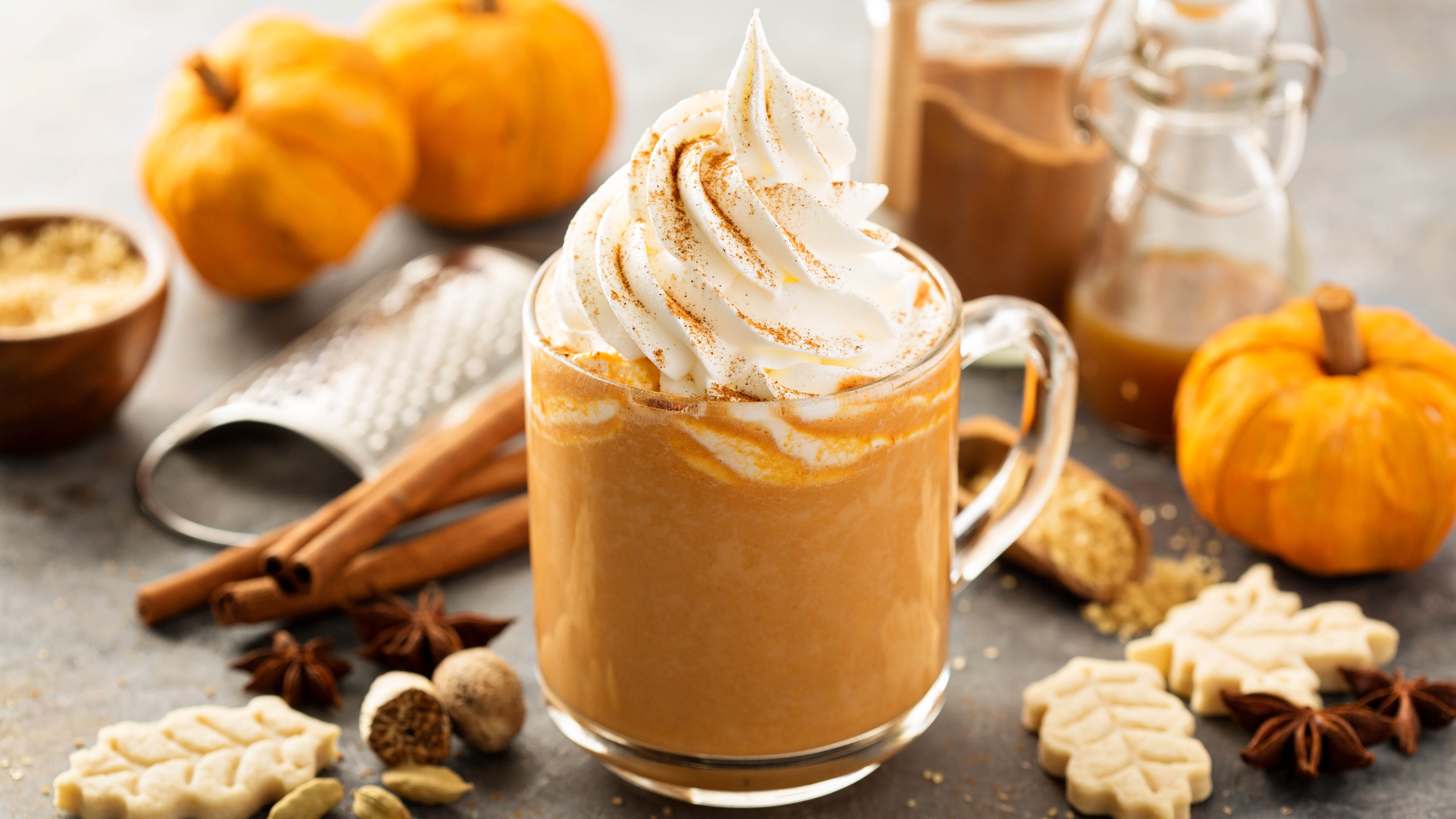 A pumpkin spiced latte in a glass jar with whipped cream on top