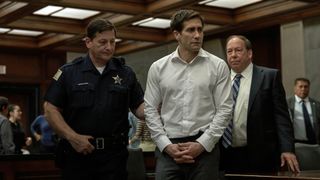 Rusty Sabich is flanked by two police officers in a court room in Presumed Innocent, one of the best Apple TV Plus shows