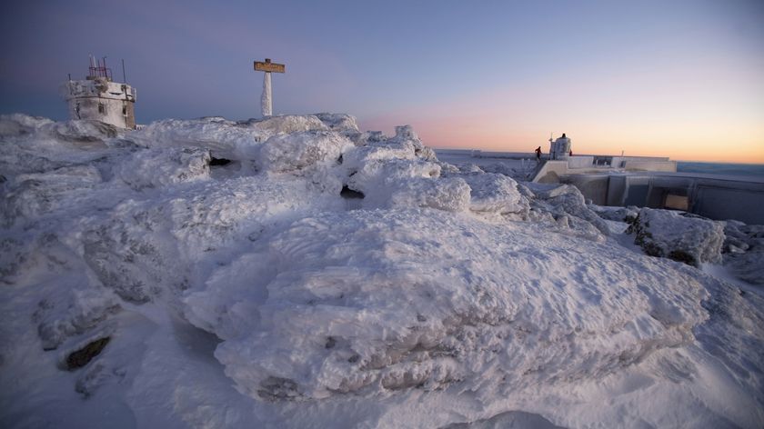 Snow-covered summit of Mount Washington at sunrise.