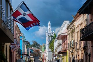 A street view of Santo Domingo, Dominican Republic, with rows of colonial houses.