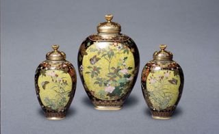 Three Japanese amphora's of different sizes with floral paintings on them.