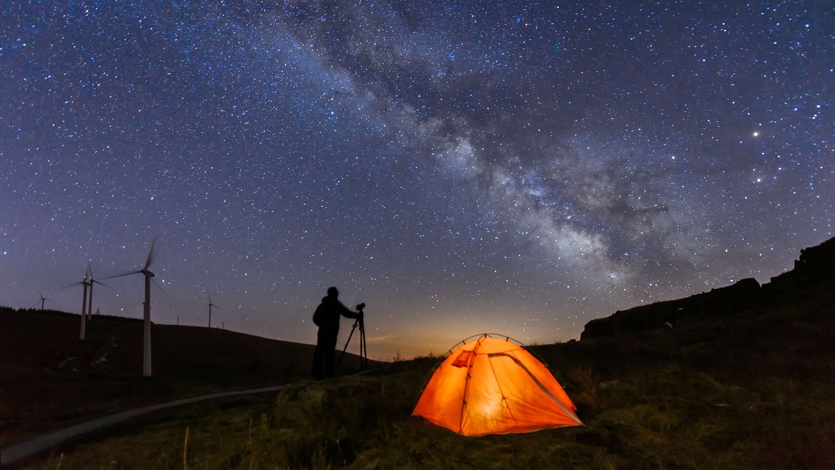 How to reduce noise in astrophotography: Photographer at night taking pictures of sky