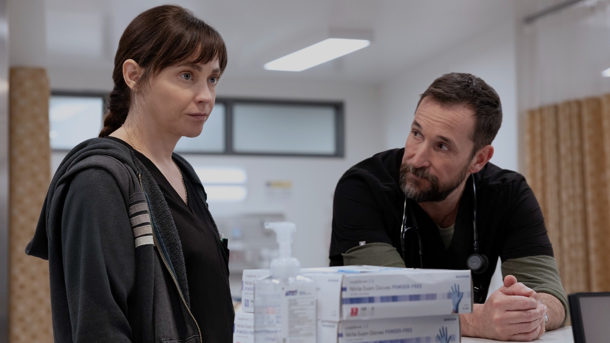Fiona Dourif looking forward and Noah Wyle looking at her.