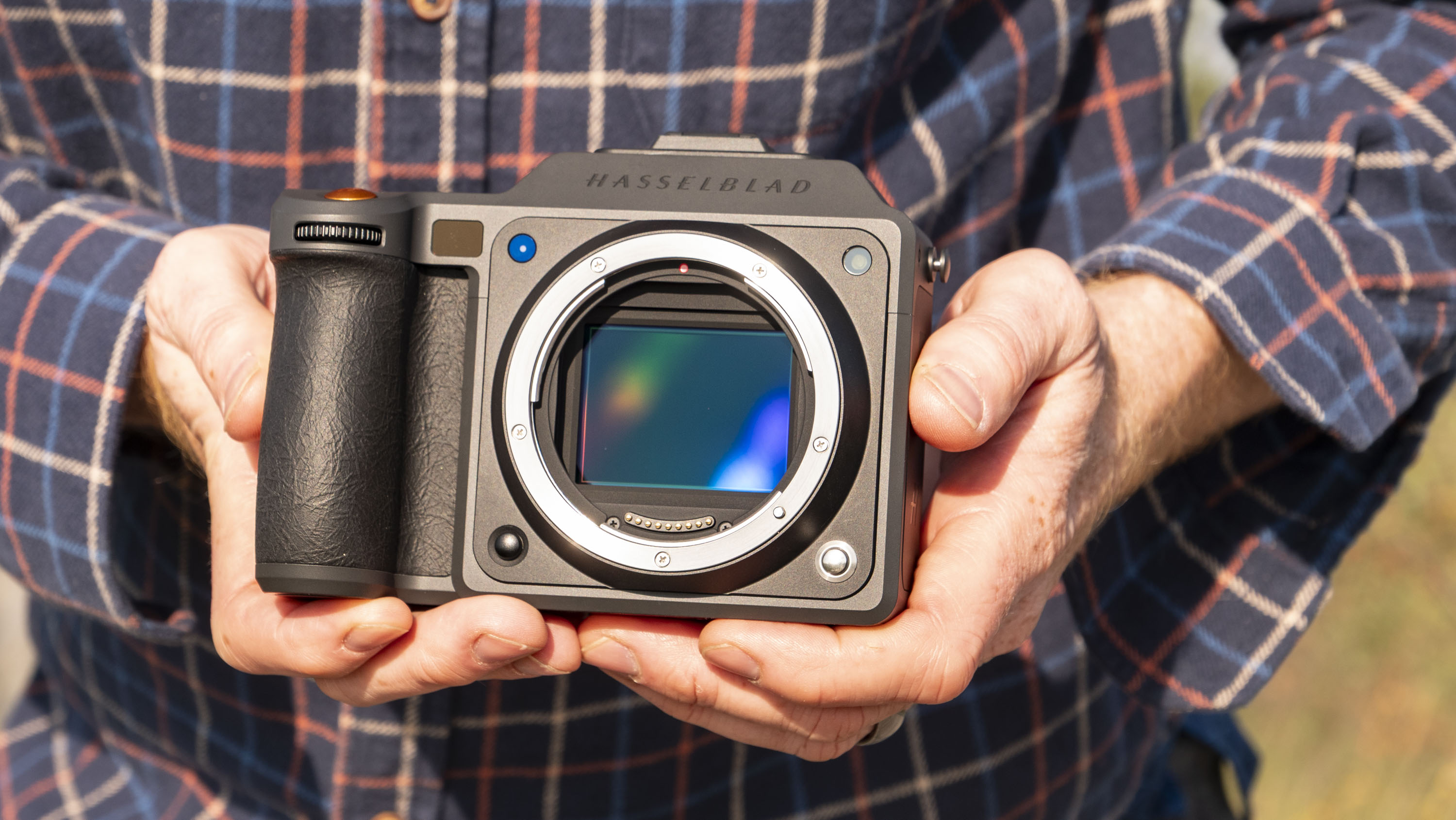Hasselblad X2D II 100C camera in the hand, outdoors at first light