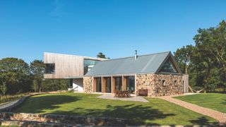 timber clad cantilever extension to stone cottage