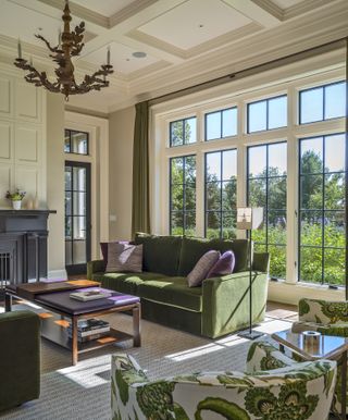 A transitional style living room with green sofa and large window