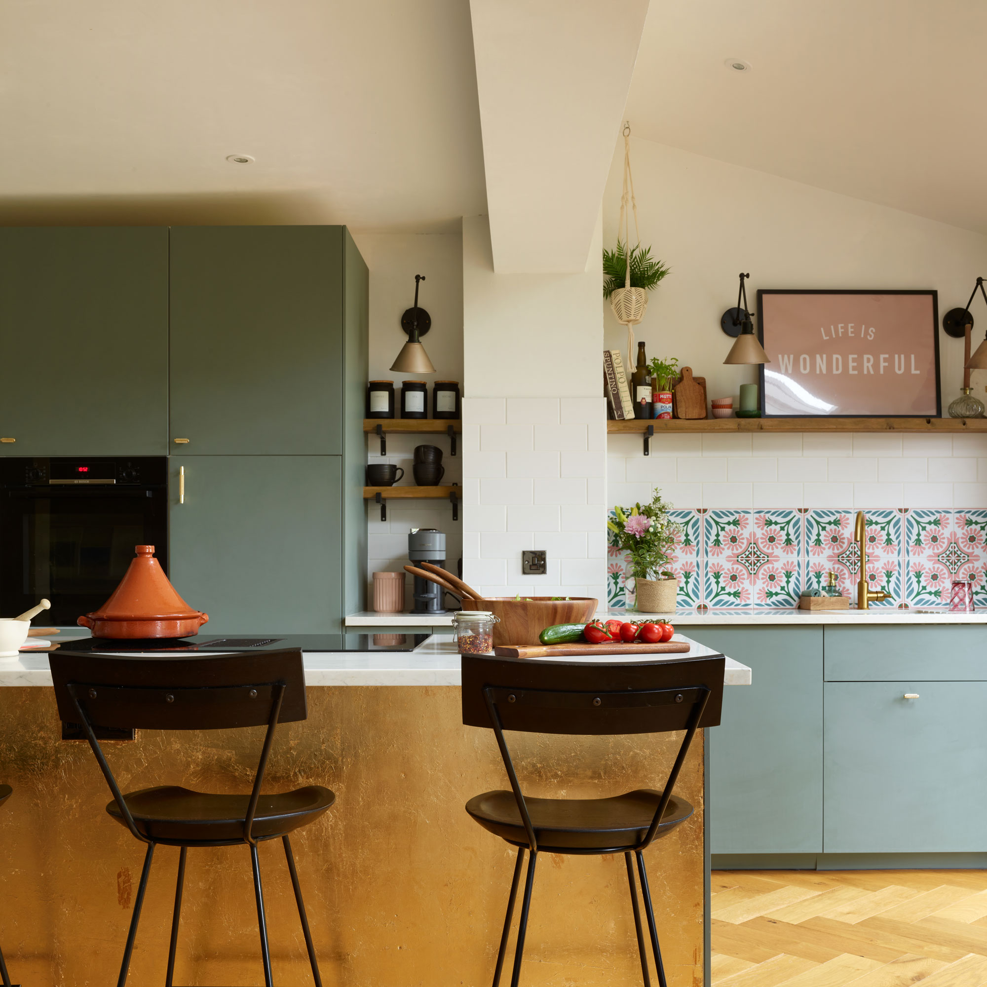 Green and white kitchen with a textured gold kitchen island