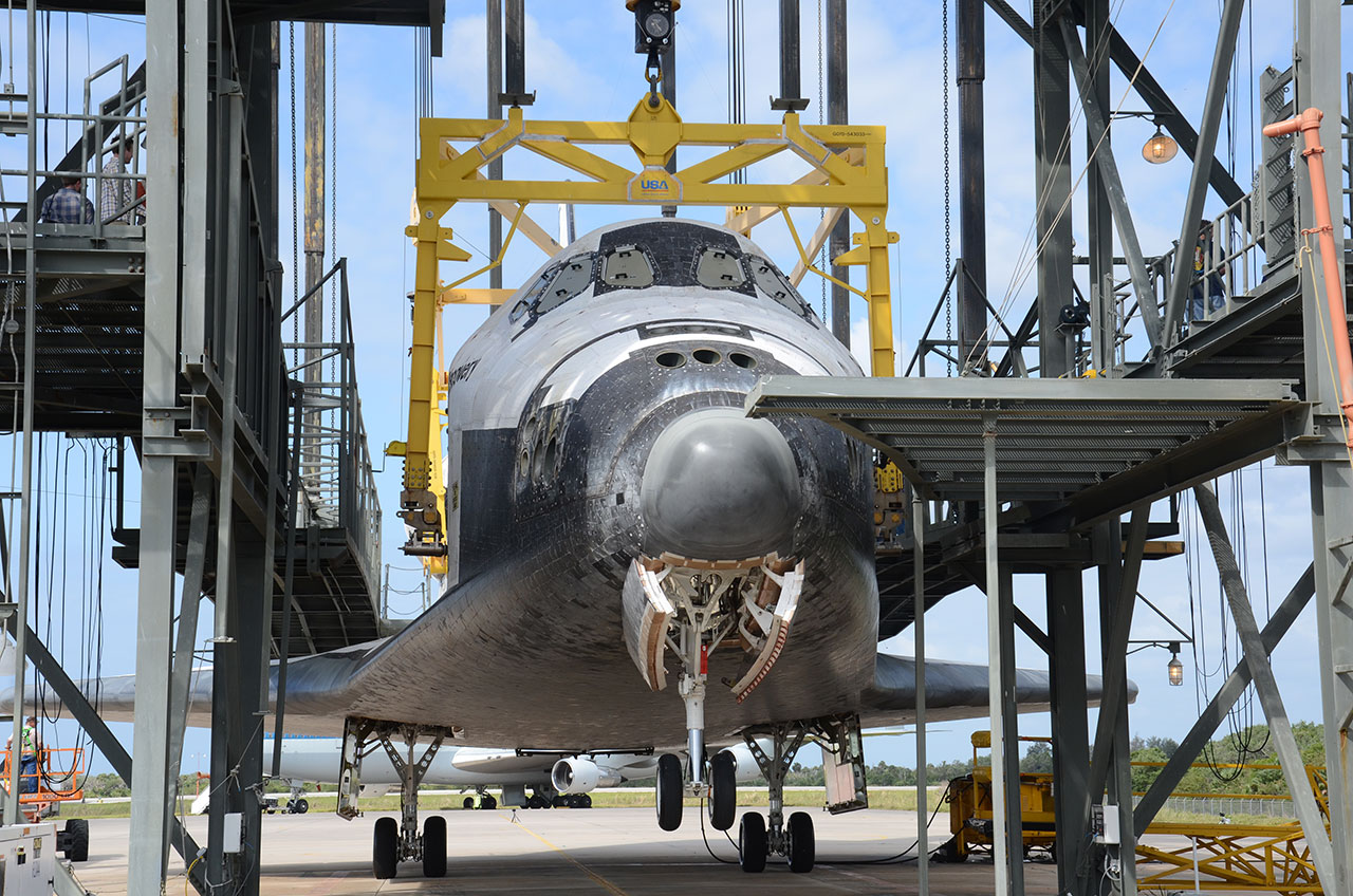 Space shuttle Discovery, suspended in Kennedy Space Center&#039;s Mate-Demate Device, was delayed a day being lifted atop its jumbo jet ride to the Smithsonian due to winds on April 14, 2012. 