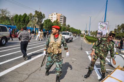 Soldiers at the scene of an attack on a military parade in Iran.
