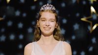 Carrie smiling at the prom in her tiara.