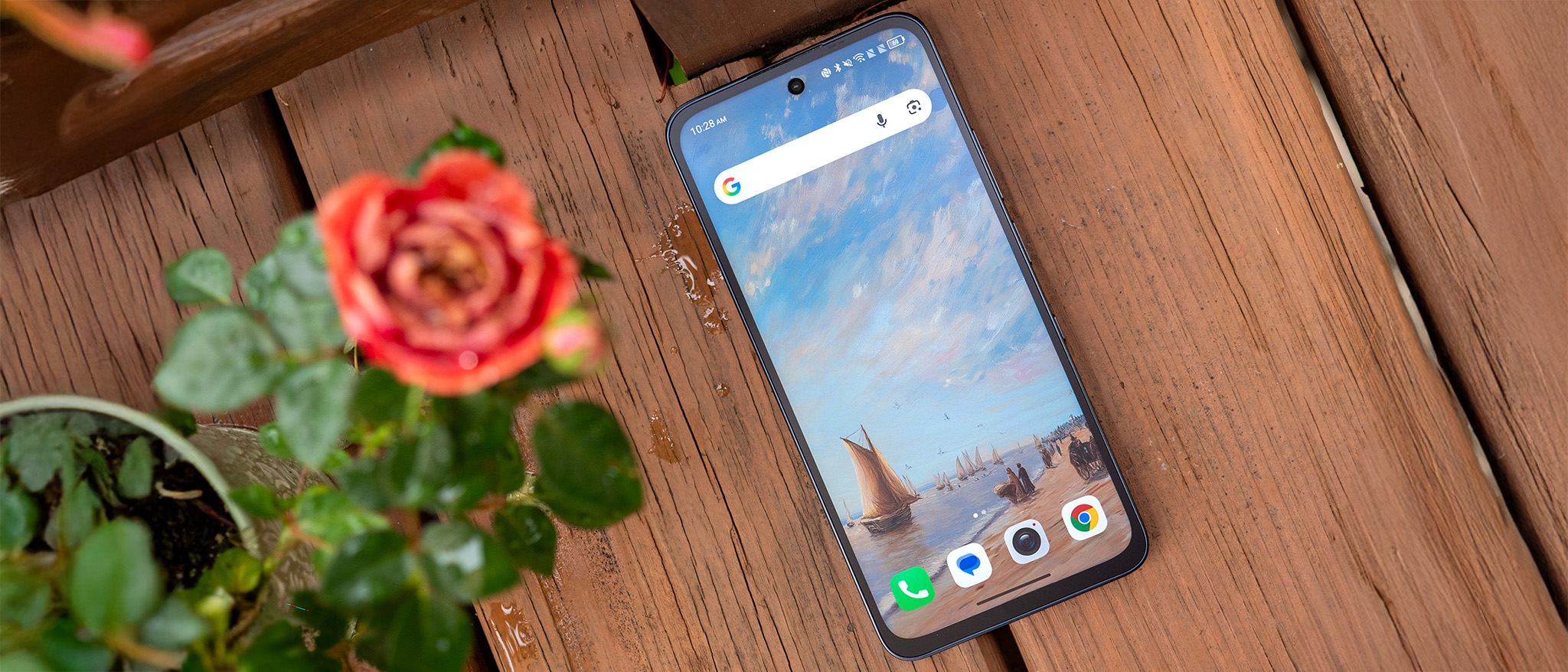 The homescreen of the TCL NXTPAPER 70 Pro with one of the default painting wallpapers, next to a rose plant