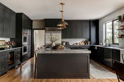 a dark grey kitchen with warm brass accents
