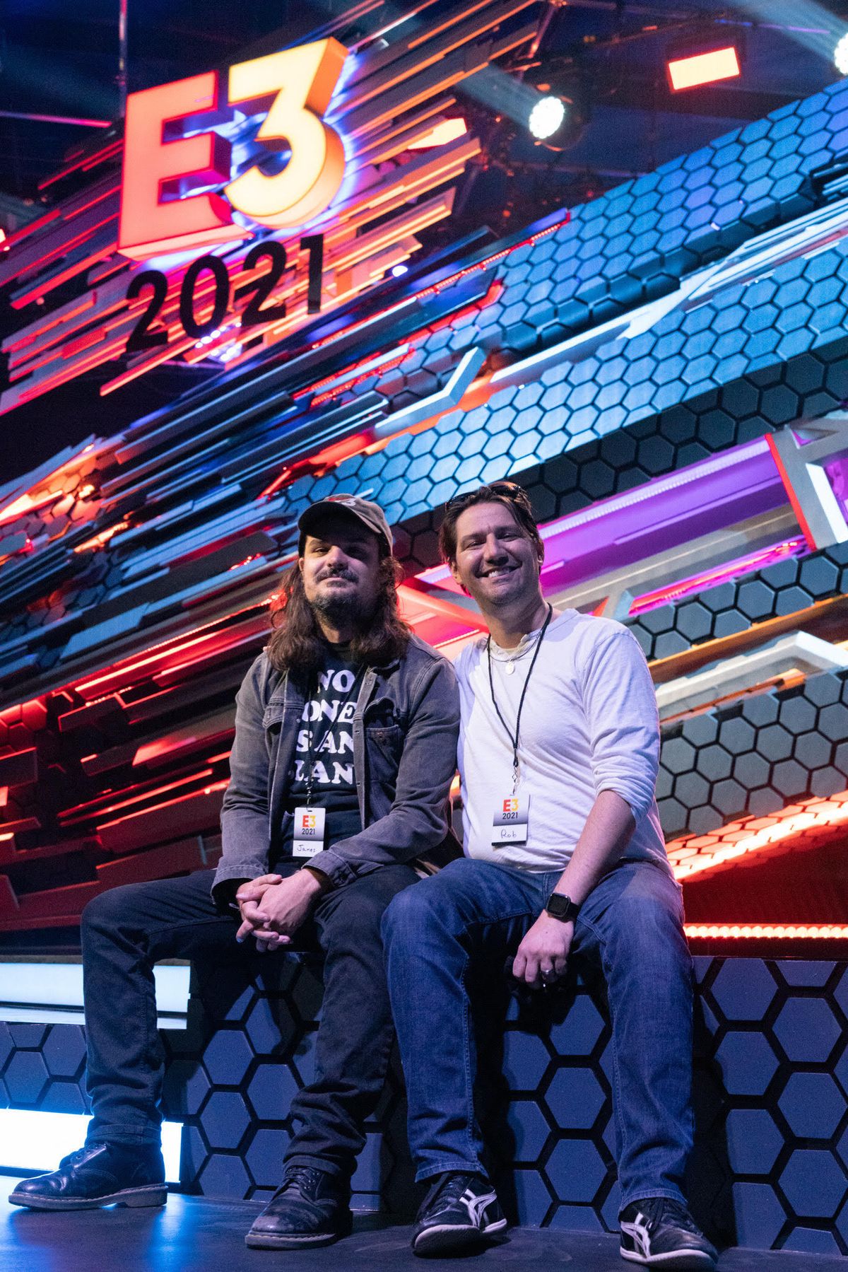 two men sitting under E3 2021 sign 