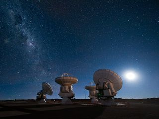 Four of the European Southern Observatory's Atacama Large Millimeter/submillimeter Array (ALMA) antennas gaze up at the night sky. Milky Way is visible at left.