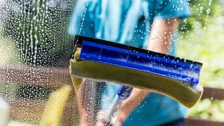 squeegee being used to clean window