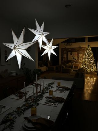 A low lit dining room with paper Christmas lights hanging from the ceiling
