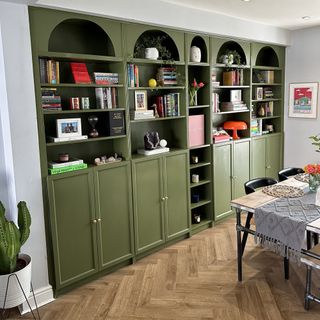 Green built in bookshelf with curved edges.