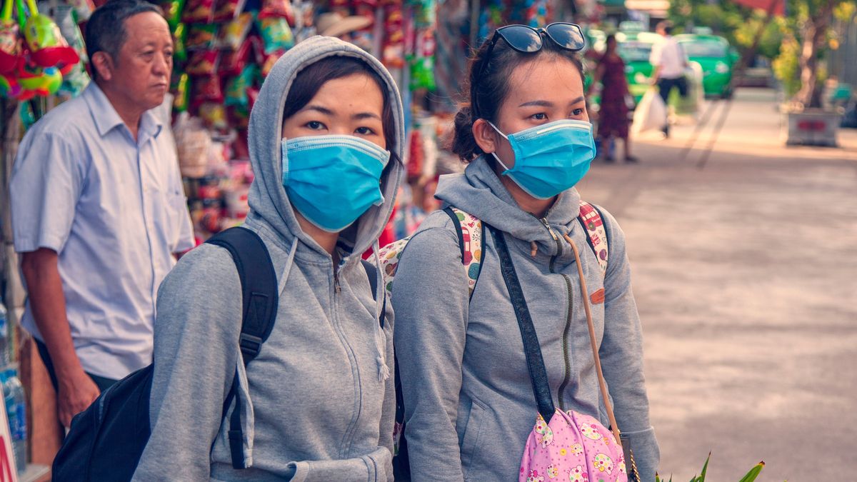 On the city street, two girls in blindfolds, the concept of the spread of the coronavirus from China, toned. E