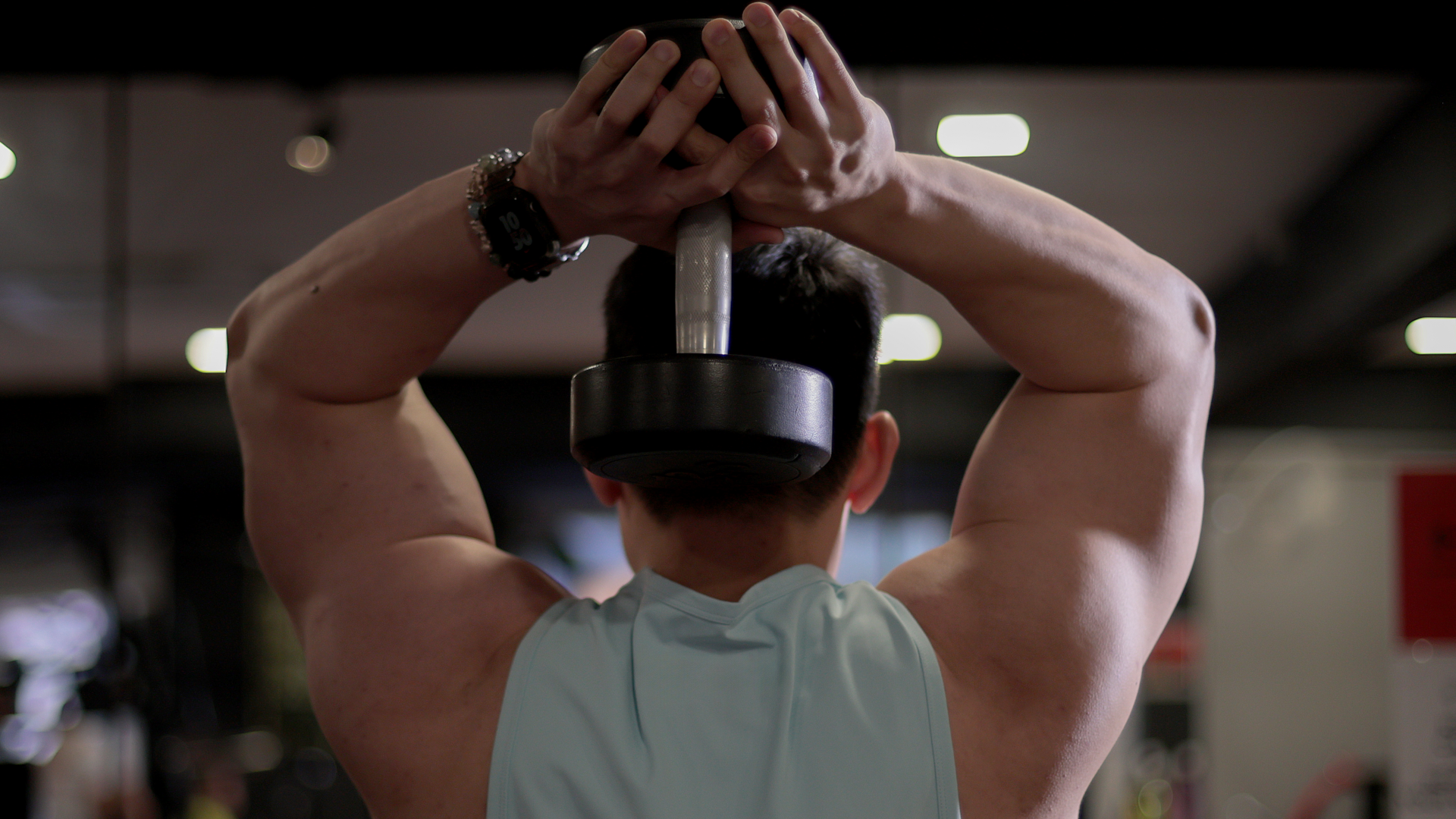 A man doing a dumbbell overhead extension