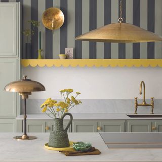 Shaker kitchen with cream cabinets, gold hardware and matching gold lights